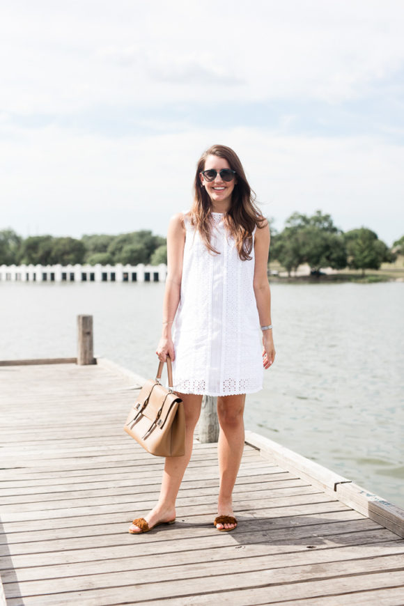 Amy Havins wears a white eyelet shift dress.