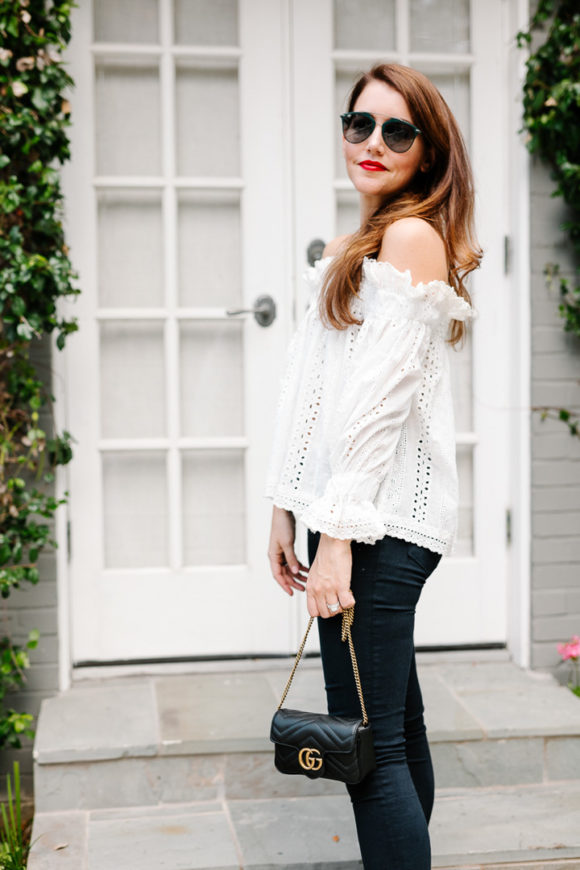 Amy Havins wears jeans and white off the shoulder blouse.