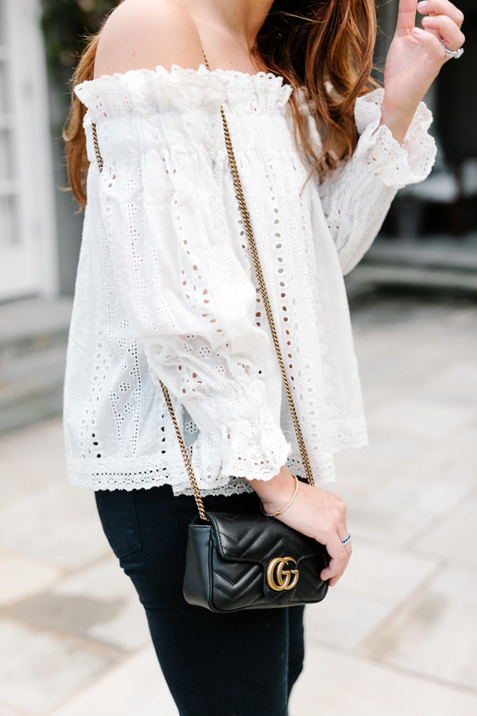 Amy Havins wears jeans and white off the shoulder blouse.