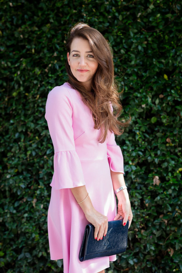 Amy Havins wears a pink shoshanna flutter sleeve dress.