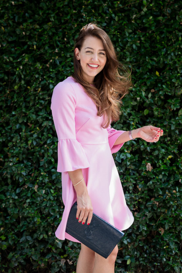 Amy Havins wears a pink shoshanna flutter sleeve dress.