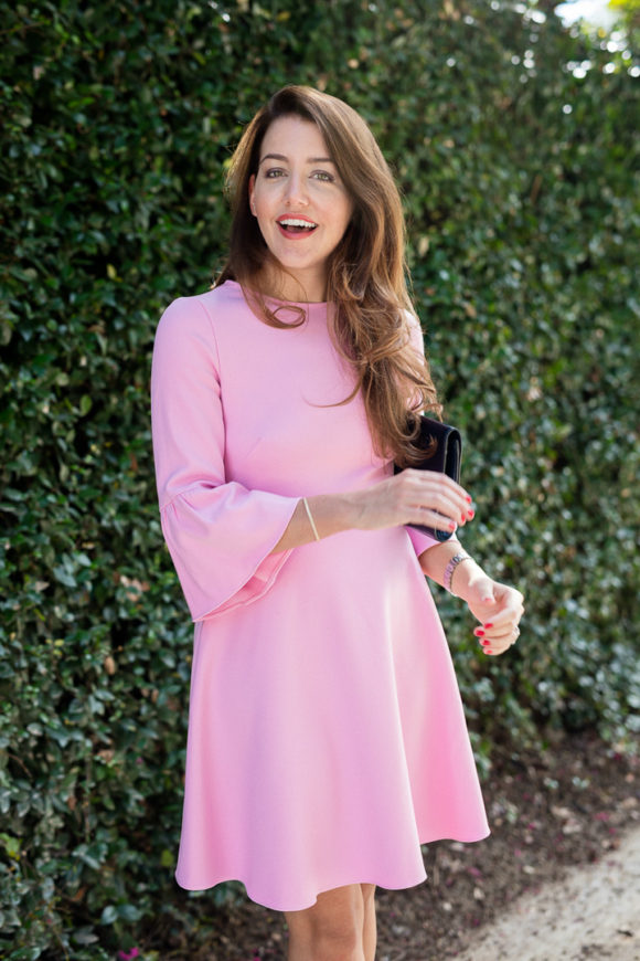 Amy Havins wears a pink shoshanna flutter sleeve dress.