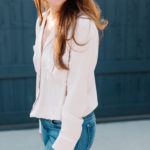 Amy Havins wears a blush blouse, ripped jeans and velvet flats.