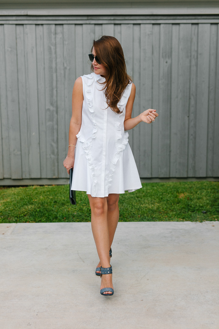 Amy Havins wears a white ruffle dress and jimmy choo shoes.
