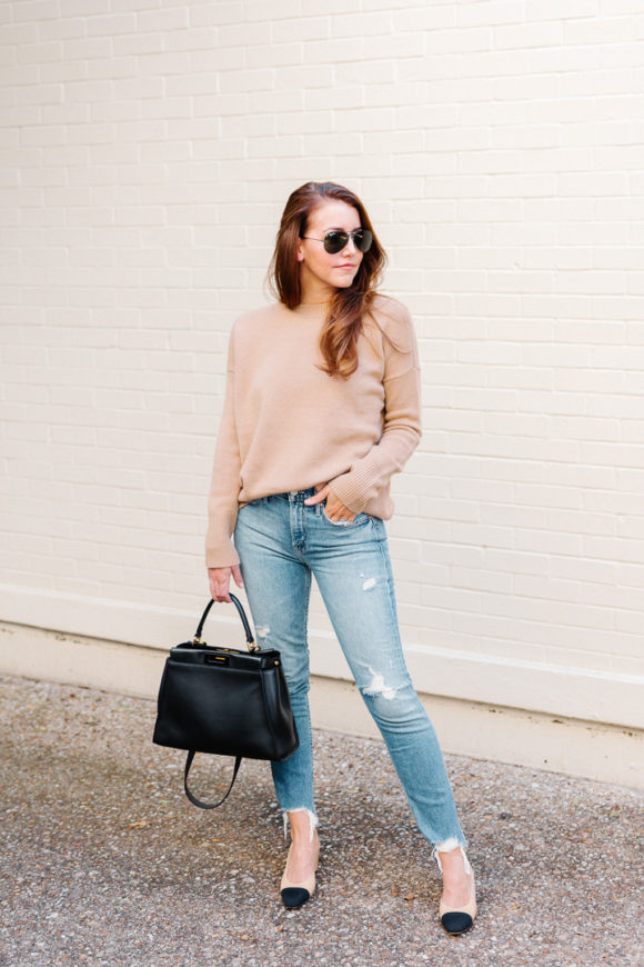 Amy Havins wears ripped jeans, a camel sweater and chanel heels.