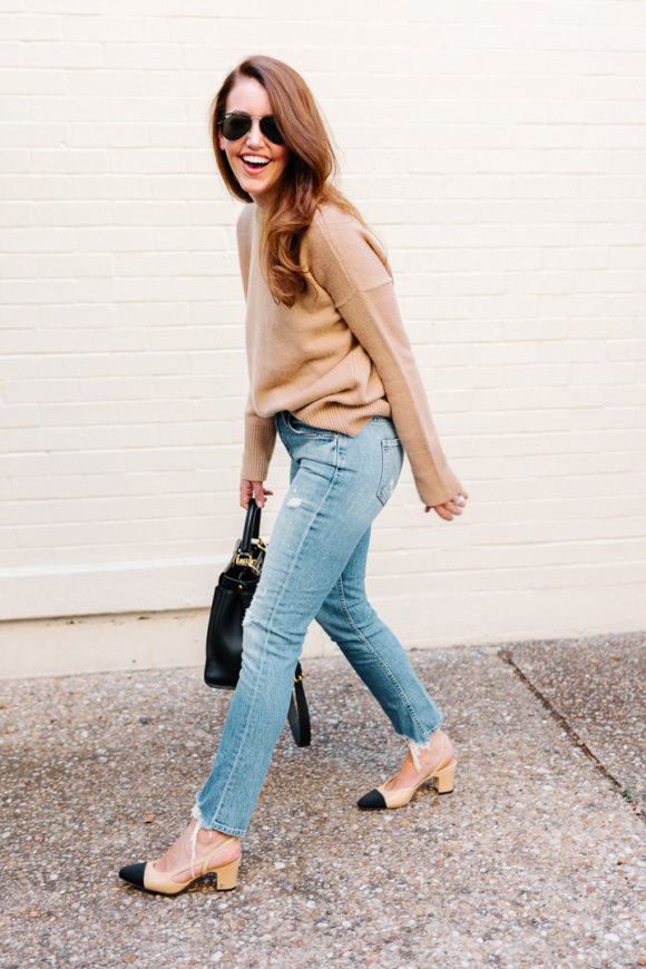 Amy Havins wears ripped jeans, a camel sweater and chanel heels.