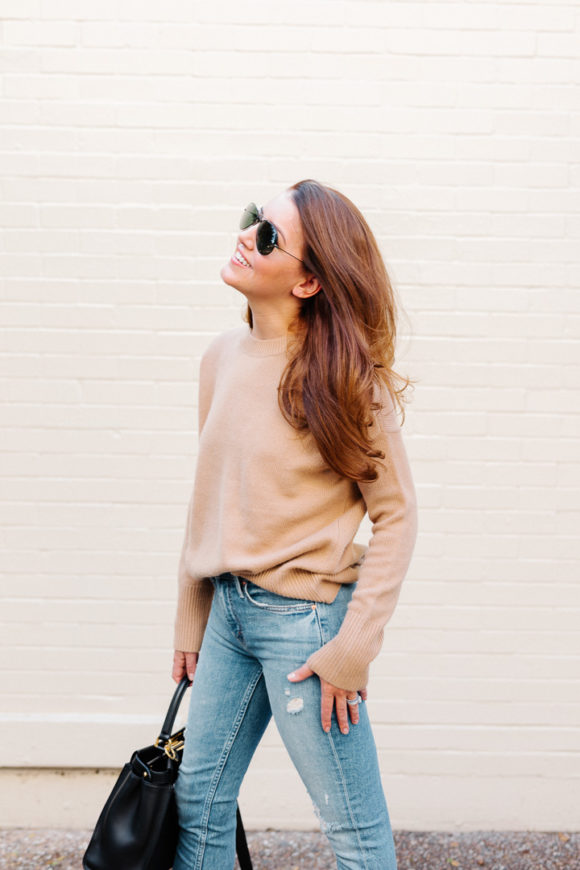 Amy Havins wears ripped jeans, a camel sweater and chanel heels.