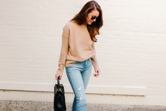 Amy Havins wears ripped jeans, a camel sweater and chanel heels.