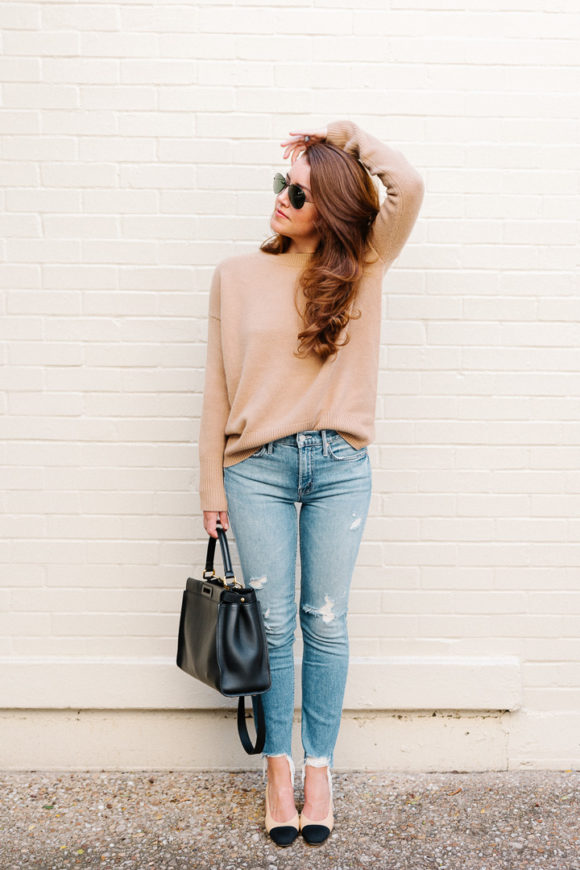 Amy Havins wears ripped jeans, a camel sweater and chanel heels.