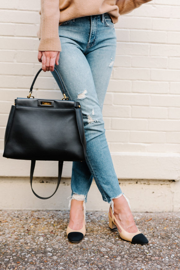 Amy Havins wears ripped jeans, a camel sweater and chanel heels.