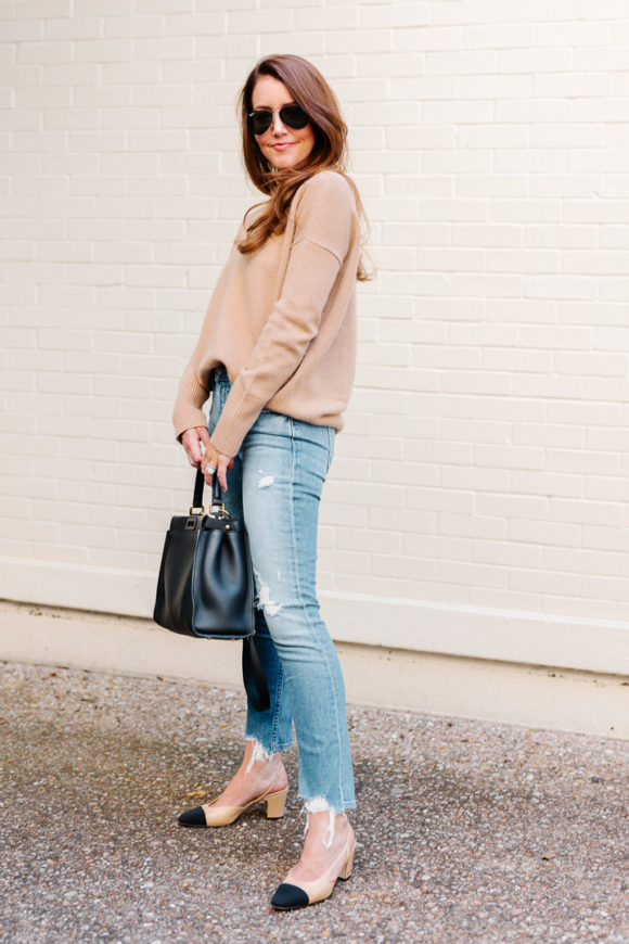 Amy Havins wears ripped jeans, a camel sweater and chanel heels.