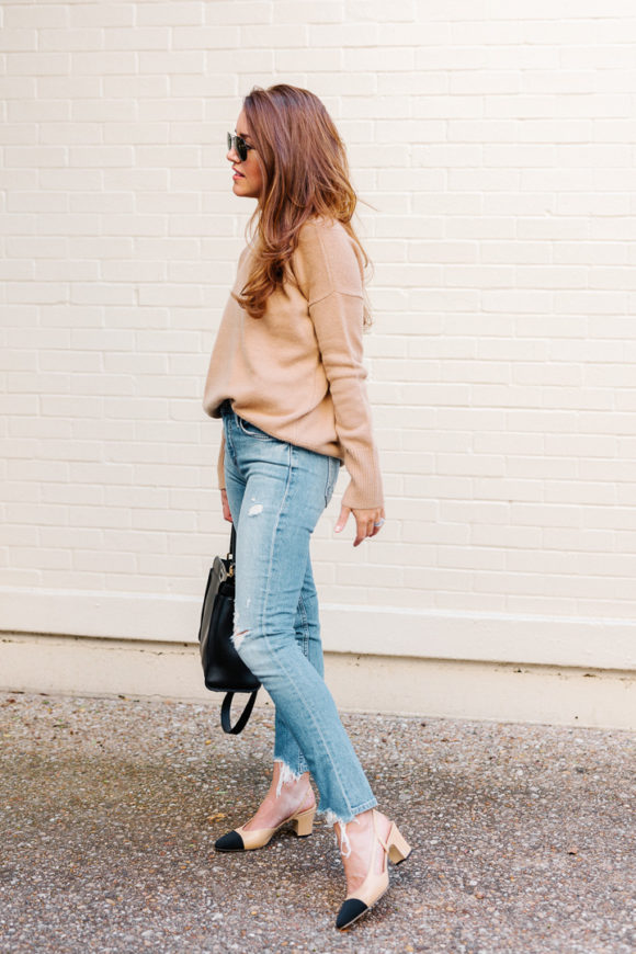 Amy Havins wears ripped jeans, a camel sweater and chanel heels.