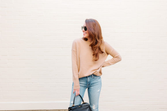 Amy Havins wears ripped jeans, a camel sweater and chanel heels.