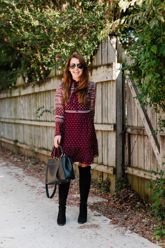 Amy Havins wears a merlot shoshanna dress and black over the knee boots.