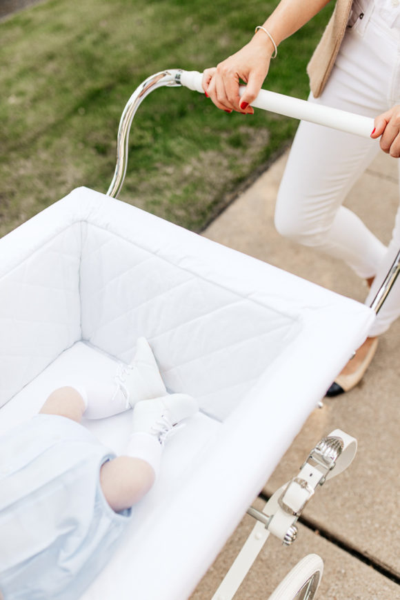 Amy Havins wears white denim and pushes Ralph in her silver cross stroller.