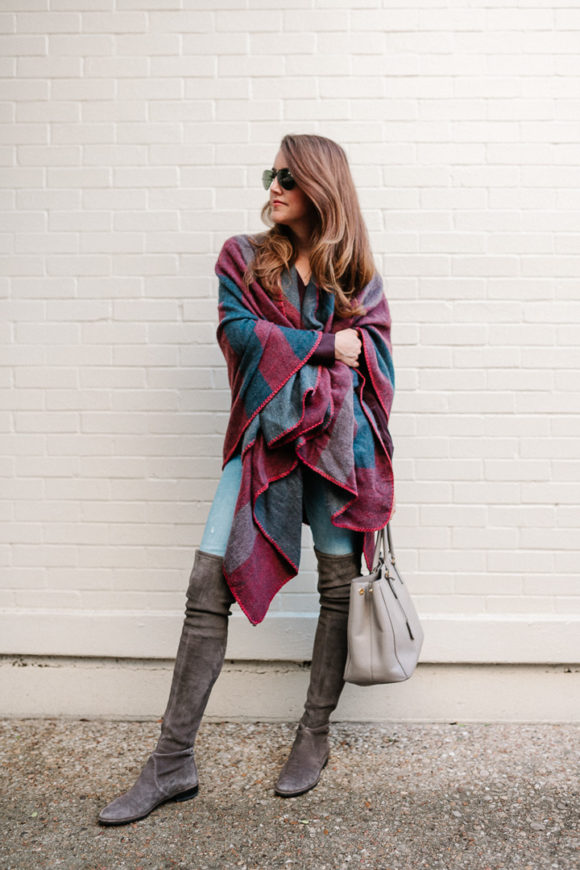 Amy Havins wears a poncho with stuart weitzman over the knee boots and jeans.