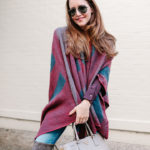 Amy Havins wears a poncho with stuart weitzman over the knee boots and jeans.