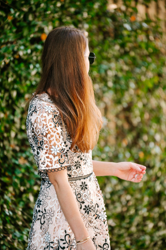 Amy Havins wears a blush and black lace dress.