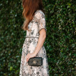 Amy Havins wears a blush and black lace dress.