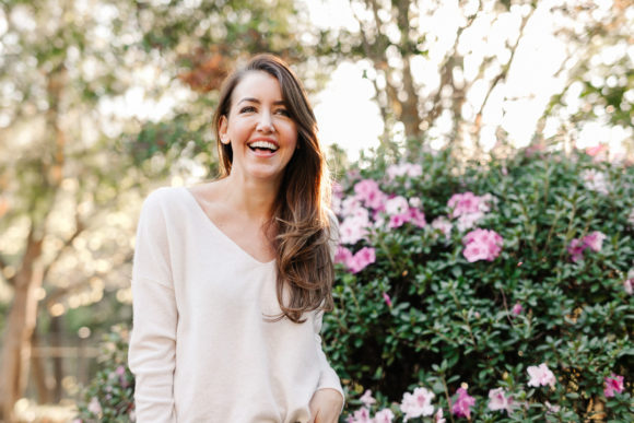 Amy Havins wears brown boots and a white sweater.