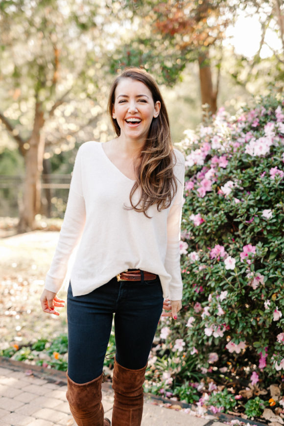 Amy Havins wears brown boots and a white sweater.