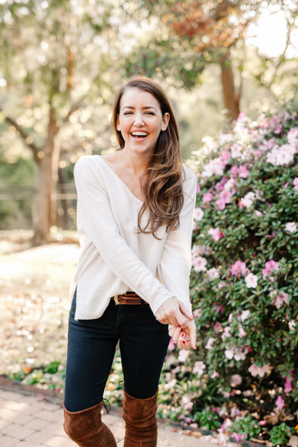 Amy Havins wears brown boots and a white sweater.