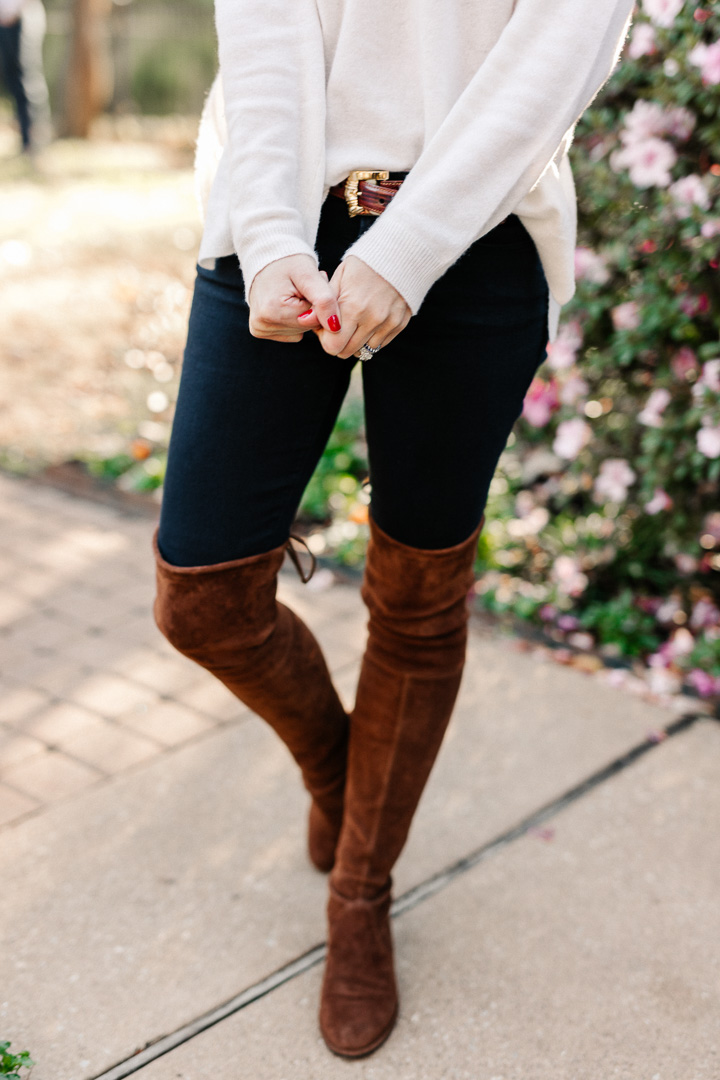 Amy Havins wears brown boots and a white sweater.