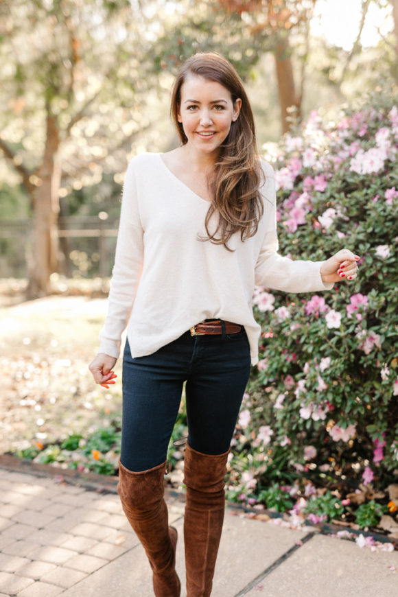 Amy Havins wears brown boots and a white sweater.