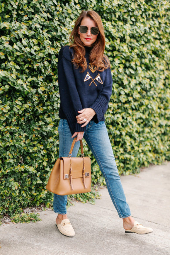 Amy havins wears a navy sweater and jeans.