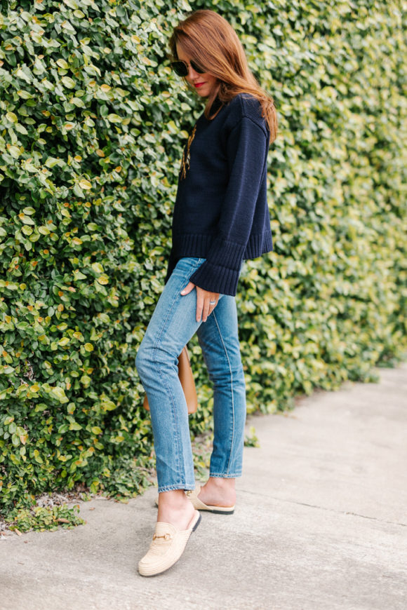 Amy havins wears a navy sweater and jeans.
