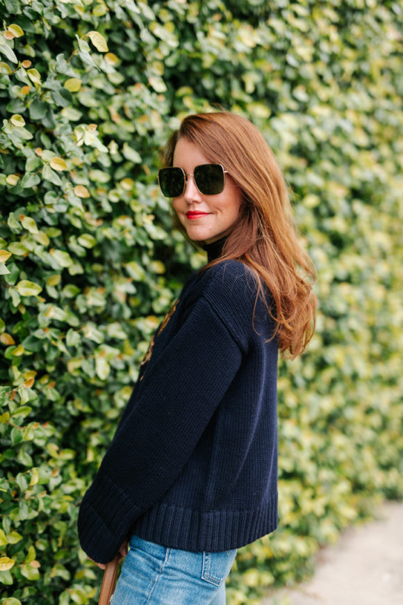 Amy havins wears a navy sweater and jeans.