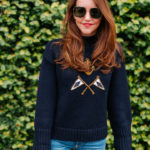 Amy havins wears a navy sweater and jeans.